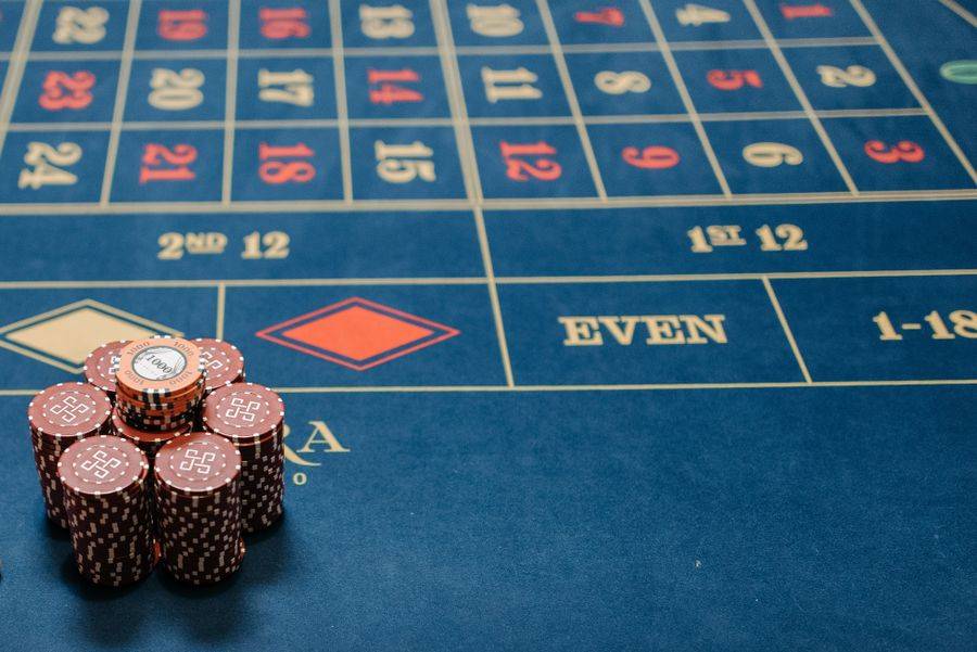 Chip kasino merah bertumpuk di atas meja