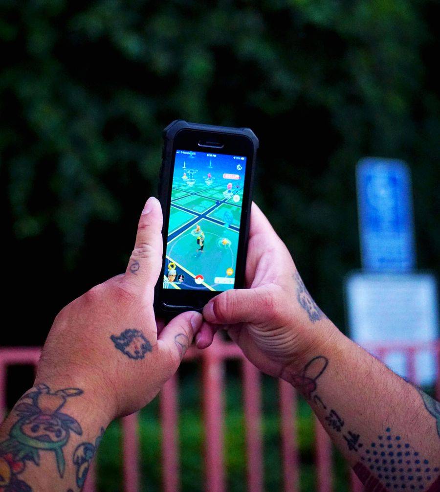 Tangan seseorang bermain game di smartphone